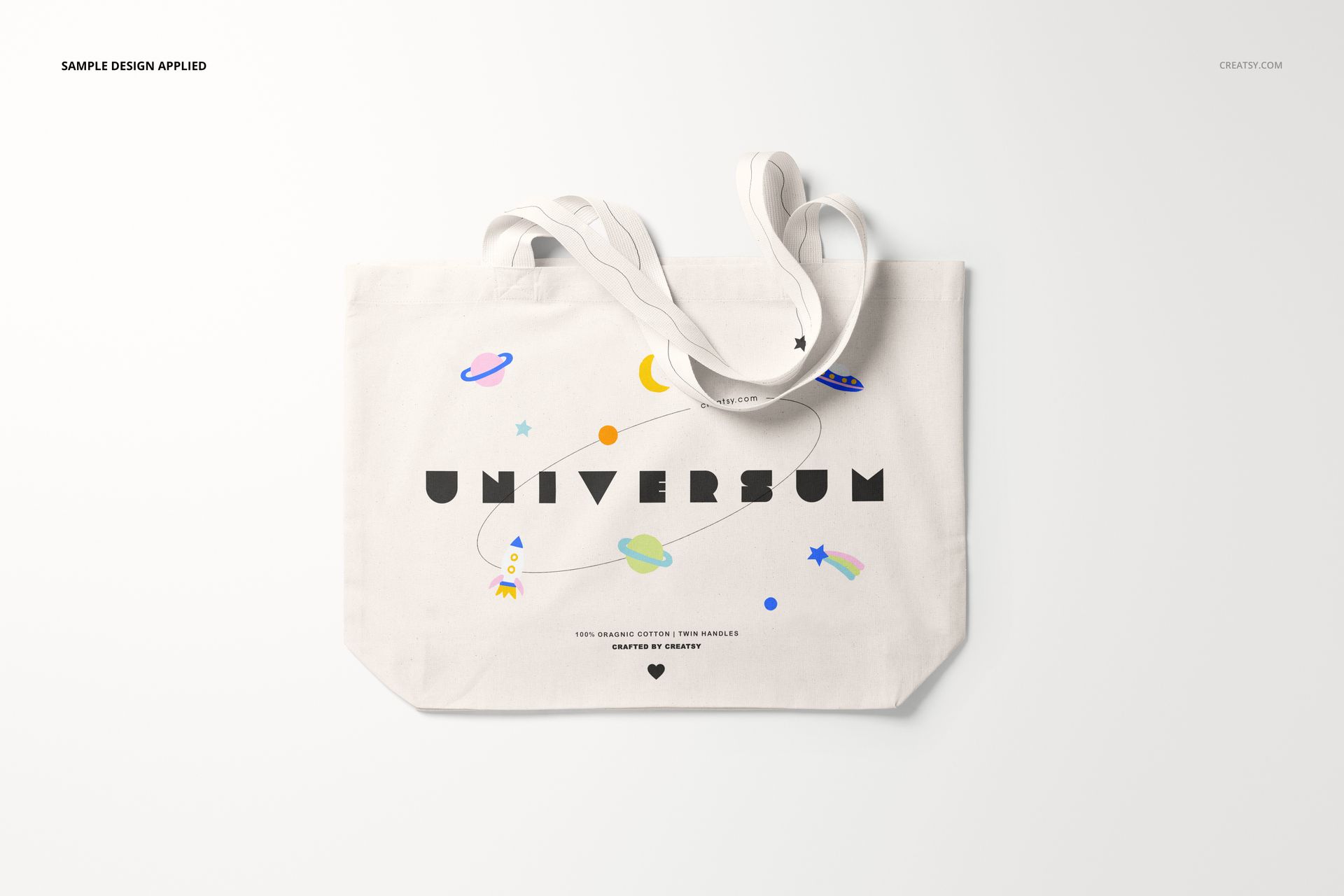 Front view of a weekender tote bag mockup with white fabric, playful space-themed graphics, and long handles.