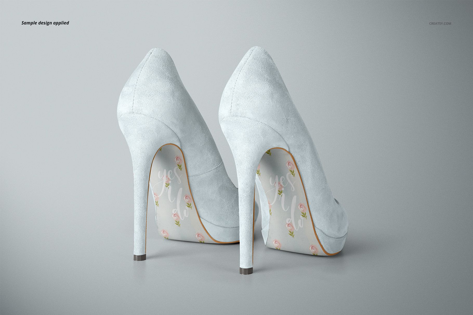 High heels mockup set featuring two white suede shoes, rear view with decorative floral soles on a gray background.