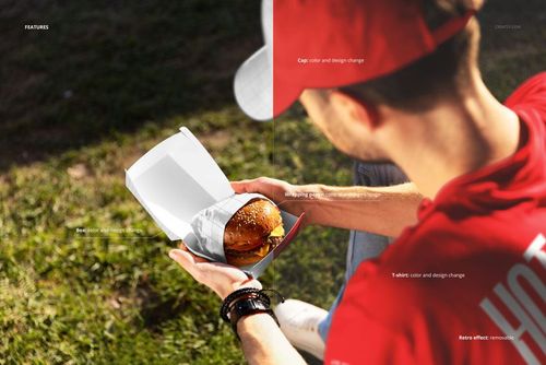 PSD mockup showing a person holding a burger in a box, with outdoor grass and sunlight in the background.