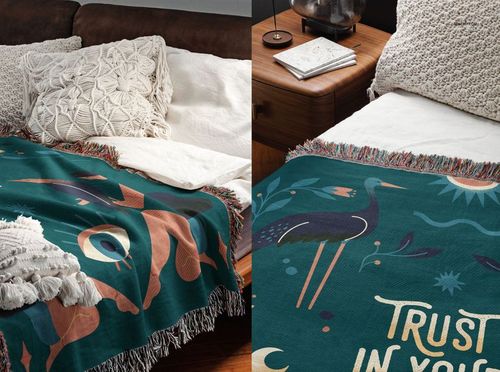PSD mockup of a woven throw blanket with multicolored design and fringe, shown on a bed next to a wooden nightstand.
