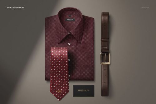 Folded men’s dress shirt in dark red with geometric pattern, paired with a polka dot tie, leather belt, and business card mockup.