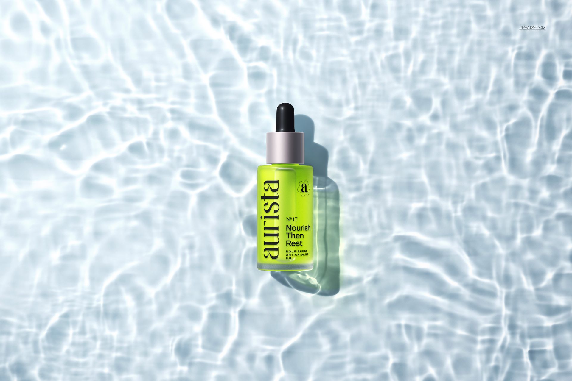 Green dropper bottle mockup with black top, placed on rippling water surface, top-down perspective.