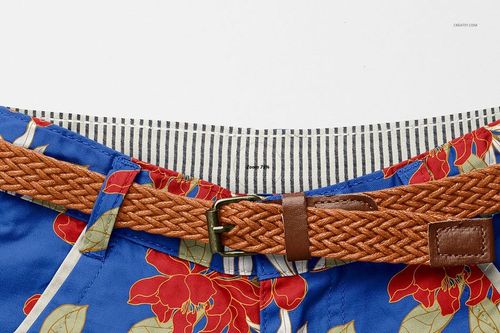 Close-up front view of kids polo shorts mockup with blue fabric, red floral pattern, striped waistband, and braided brown belt.