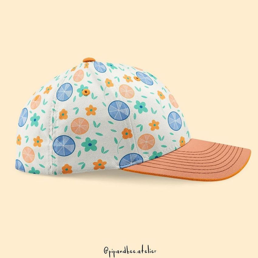 Fullcap mockup featuring a side view of a cap with a colorful floral and citrus pattern, set against a light beige background.