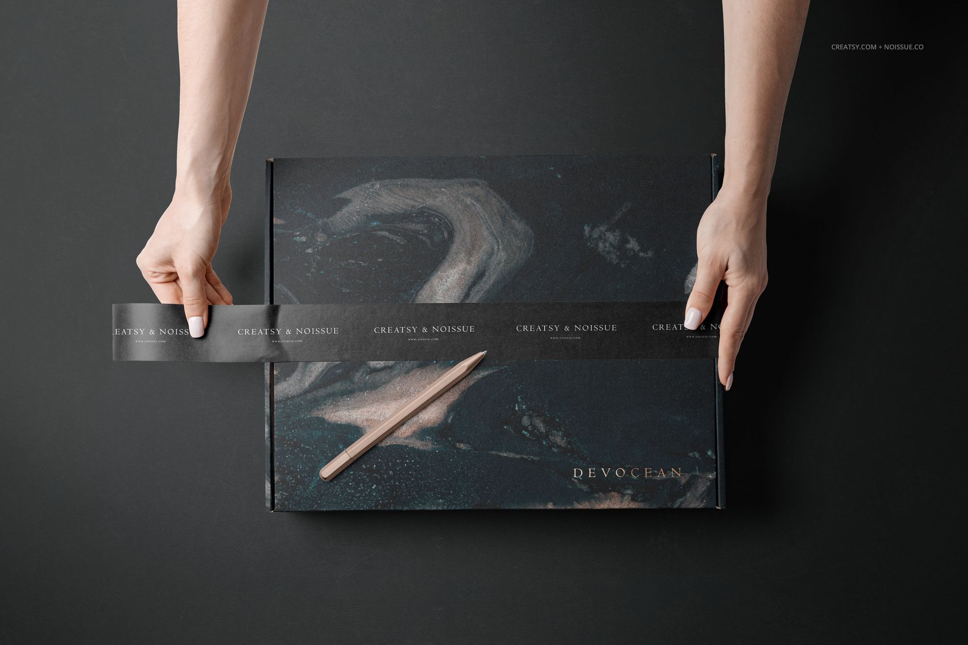 Mockup of a mailing box featuring swirling dark colors, hands sealing it with clear tape, shown on a black background.