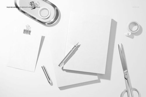 Flat lay of two white planners and a card mockup with pen, scissors, and paper clip on a clean workspace.