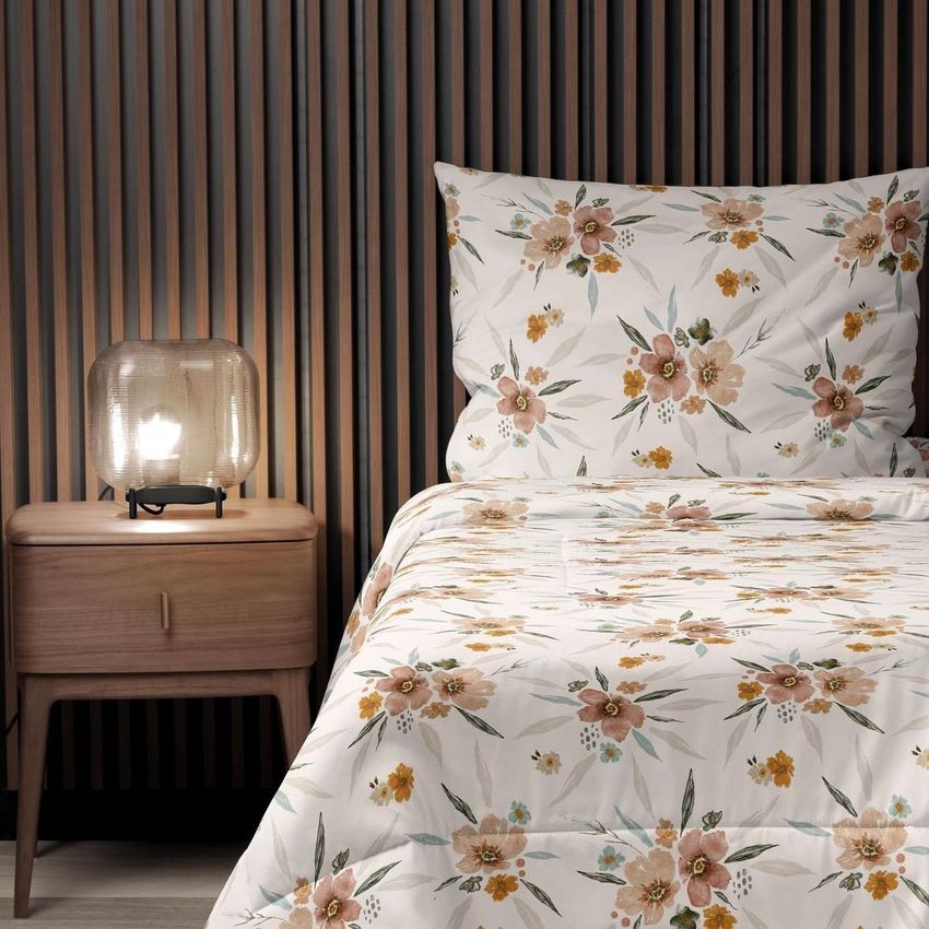 Microfiber comforter mockup on a bed with a white base and orange floral pattern, next to a wooden nightstand and lamp.