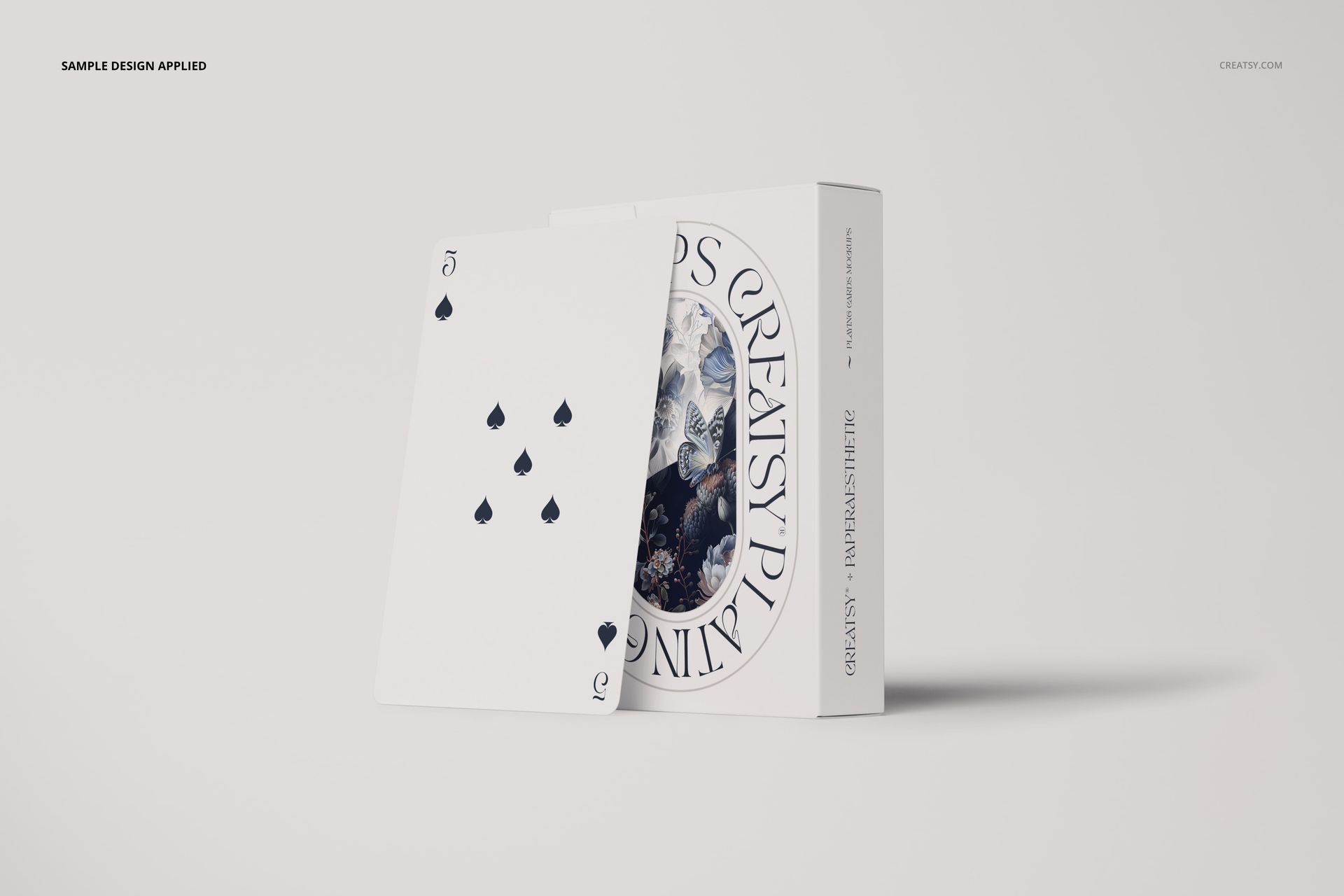 Front view of a playing card with a white box featuring circular text and a floral pattern, set on a light background.