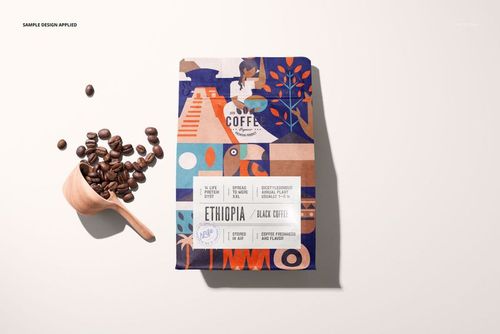 Coffee bag PSD mockup featuring a vibrant, multi-colored abstract design and a wooden scoop with scattered coffee beans.