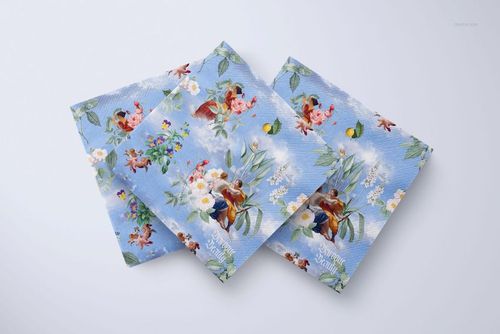 Home and living napkin PSD mockup showing three decorative napkins with colorful prints on a white tabletop.
