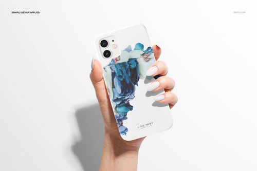Front perspective of a white iPhone 12 snap case mockup with blue artistic design, held by a hand against a light surface.