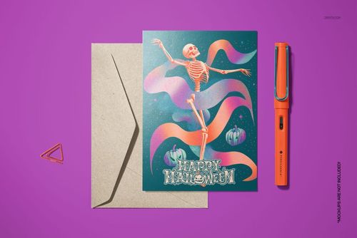 Halloween card mockup with vintage skeleton artwork, colorful ribbons, pumpkins, and an orange pen on a purple background.