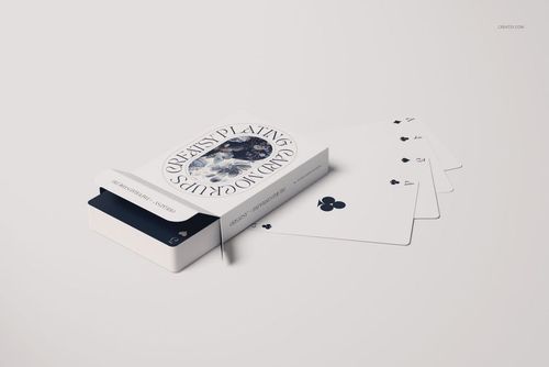 Playing cards mockup with an open box and four cards spread out on a light surface, showing club suit designs.