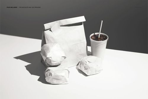 Front view of a PSD mockup displaying wrapped burgers, a paper bag, and a drink cup with straw in soft lighting.
