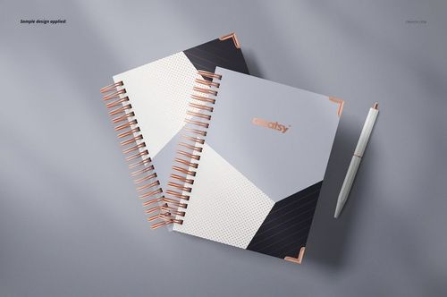 Wire-bound planner mockup featuring two spiral notebooks with abstract covers and a pen, displayed from a top view.