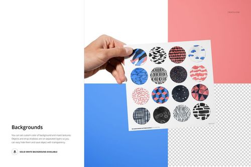 Hand holding a velvet swatches card mockup with sixteen round fabric samples in various colors and patterns, front view.