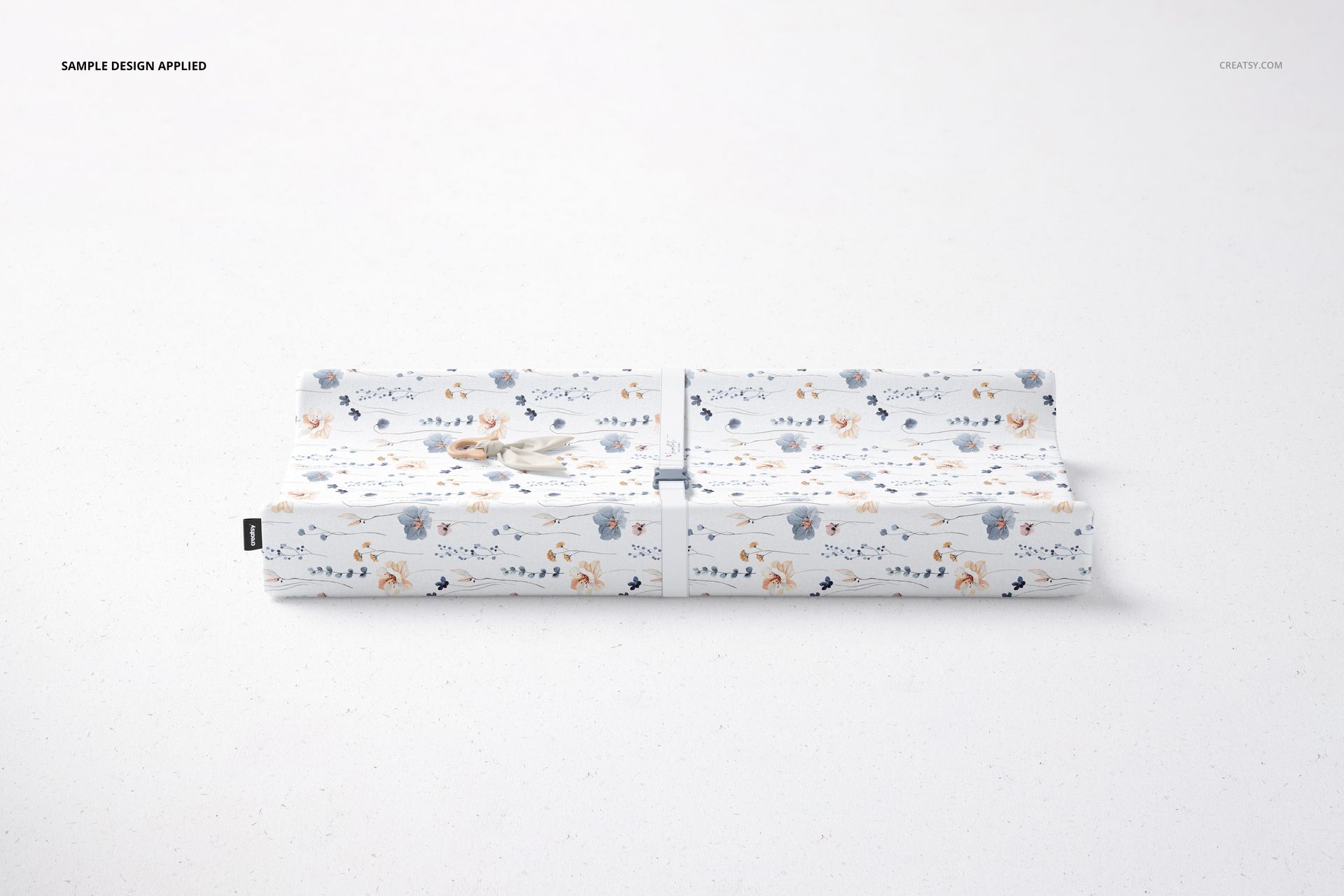 Rectangular changing pad mockup featuring soft blue, orange, and beige floral and animal motifs on white background.