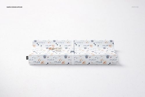 Rectangular changing pad mockup featuring soft blue, orange, and beige floral and animal motifs on white background.