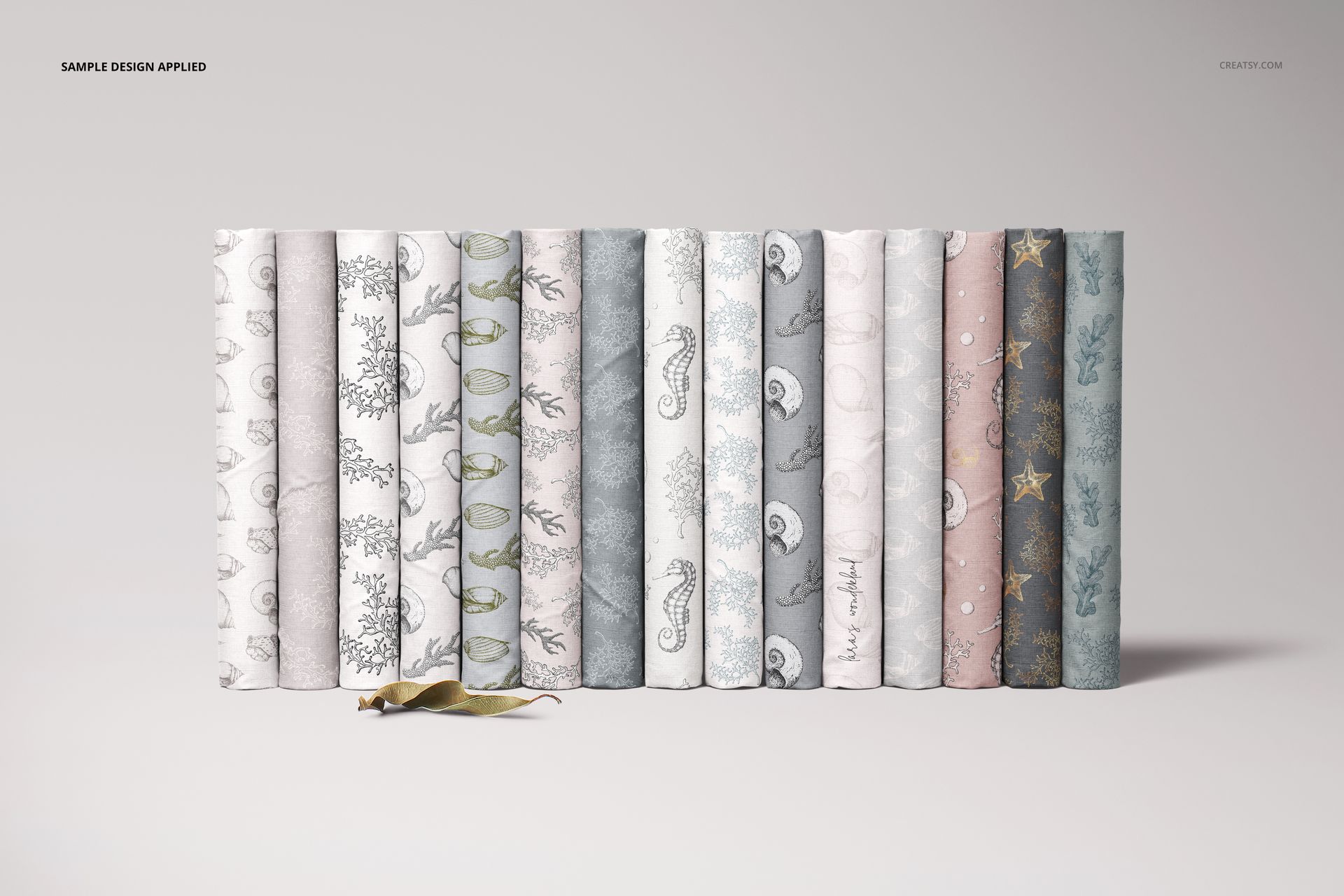 Folded fabrics mockup set featuring fifteen fabric pieces with delicate designs, displayed side by side on a plain surface.