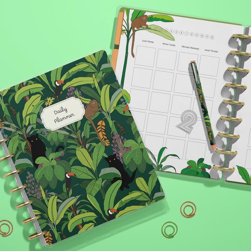 Spiral planner mockup with one planner closed displaying a leafy jungle design and the other open to a blank schedule page.