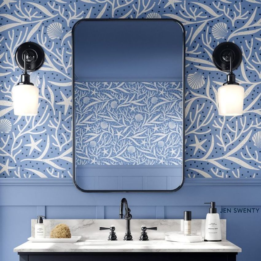 Bathroom mockup featuring a blue and white coral pattern wallpaper, a rectangular mirror, and a white sink with black fixtures.
