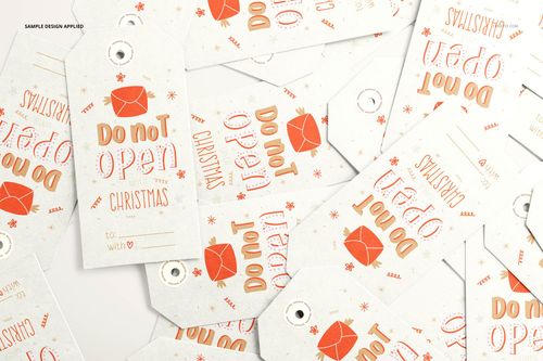 PSD mockup showing assorted paper gift tags with printed holiday graphics and messages, arranged in a random layout.