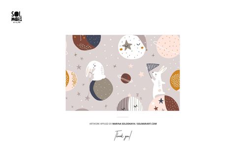 Hooded baby towel mockup featuring a playful space-themed pattern with rabbits, stars, and planets on a soft background.