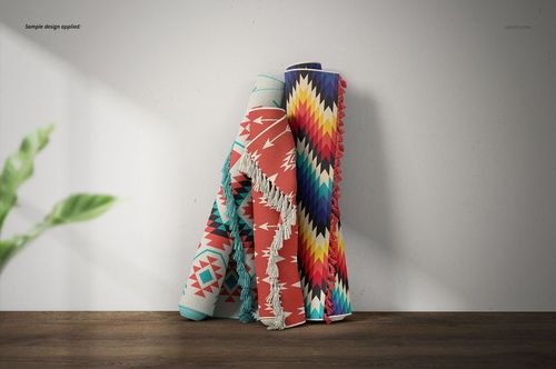 PSD mockup of fringed rugs with vibrant angular patterns, arranged upright beside a plain wall and a leafy green plant.