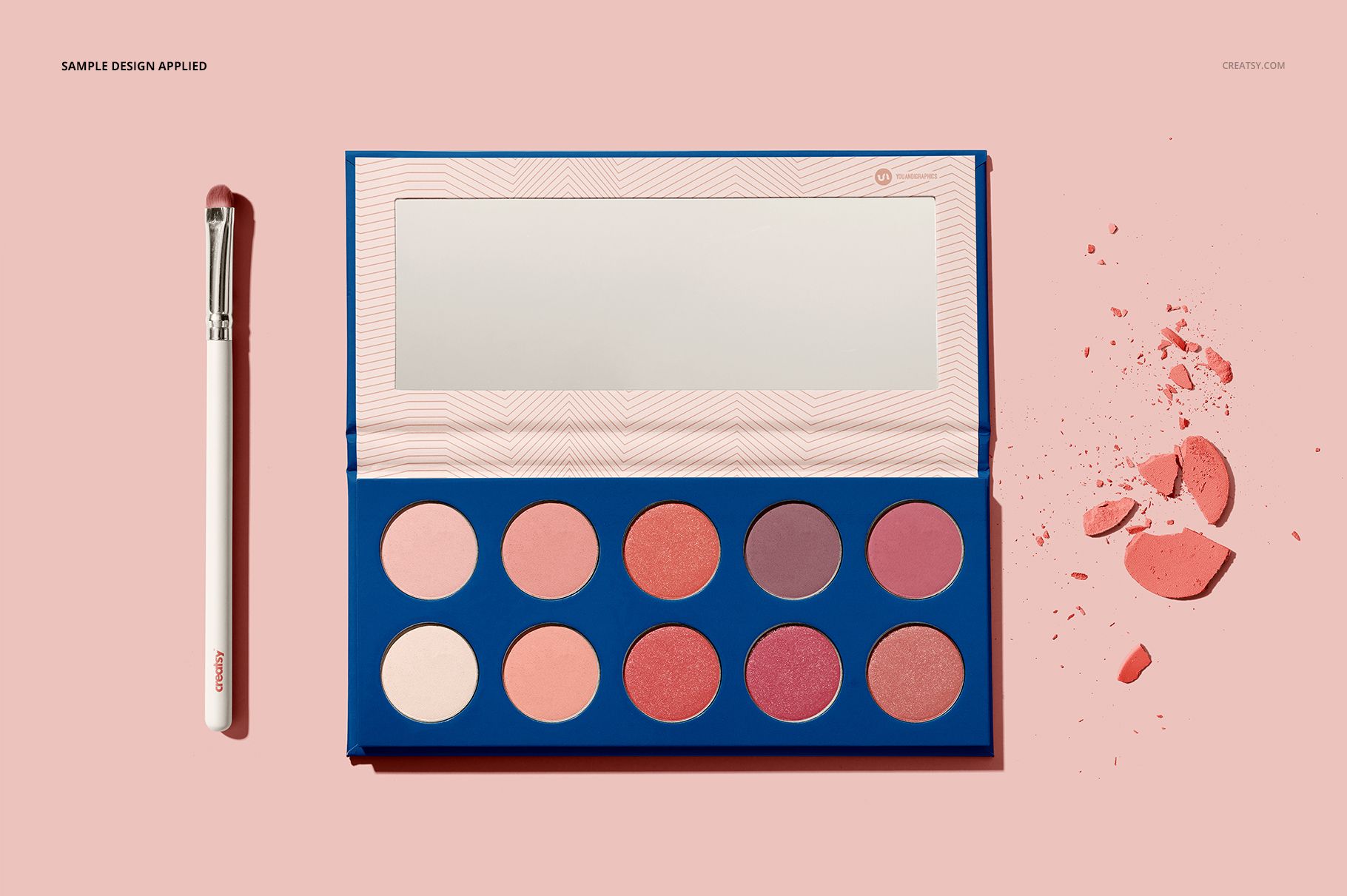 Eyeshadow palette mockup with ten round pans in pink and mauve shades, open to show mirror, on pastel background.