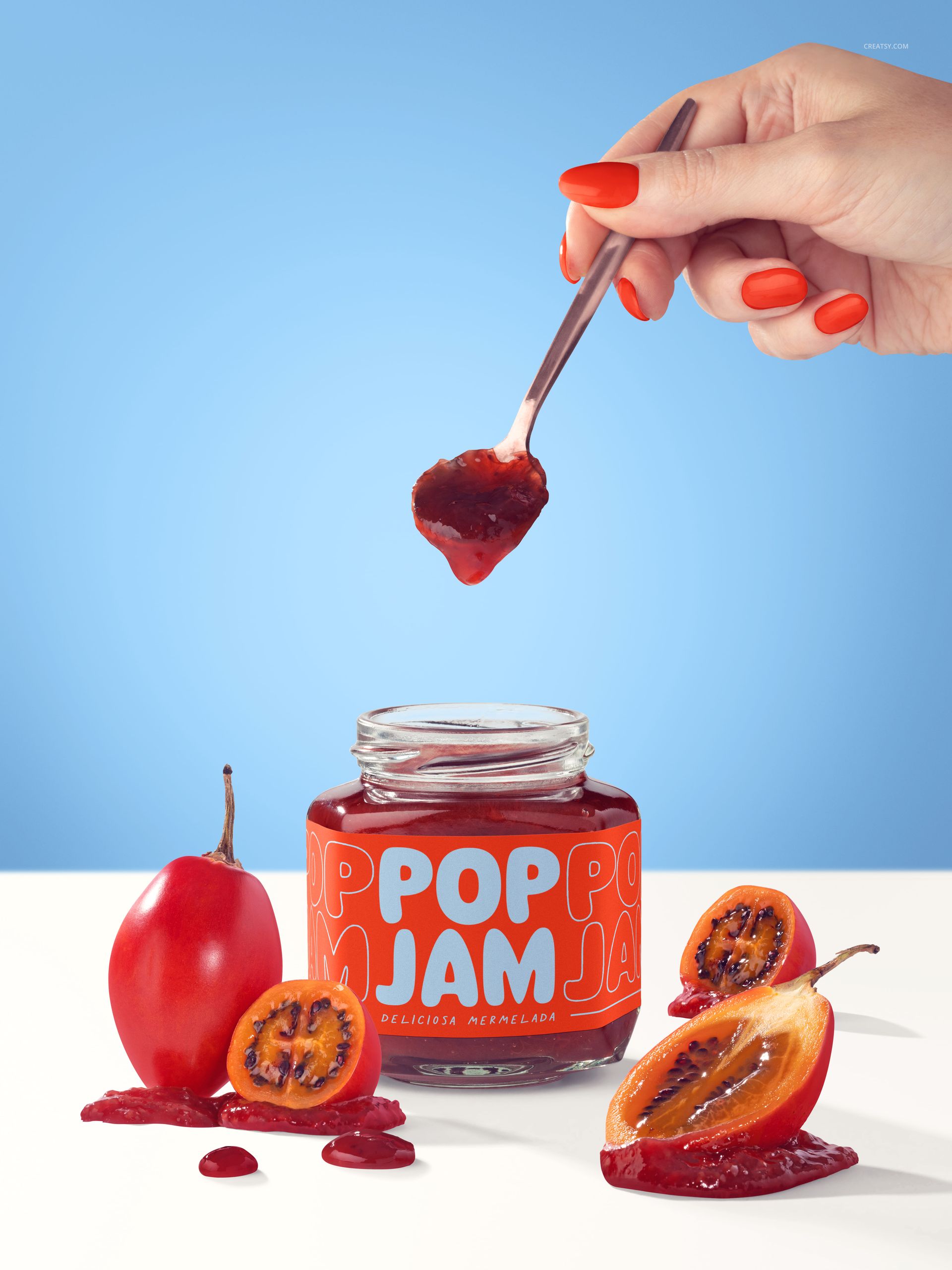 PSD mockup featuring a tamarillo jam jar, red jam spilled on the surface, and a hand holding a spoon against a blue background.