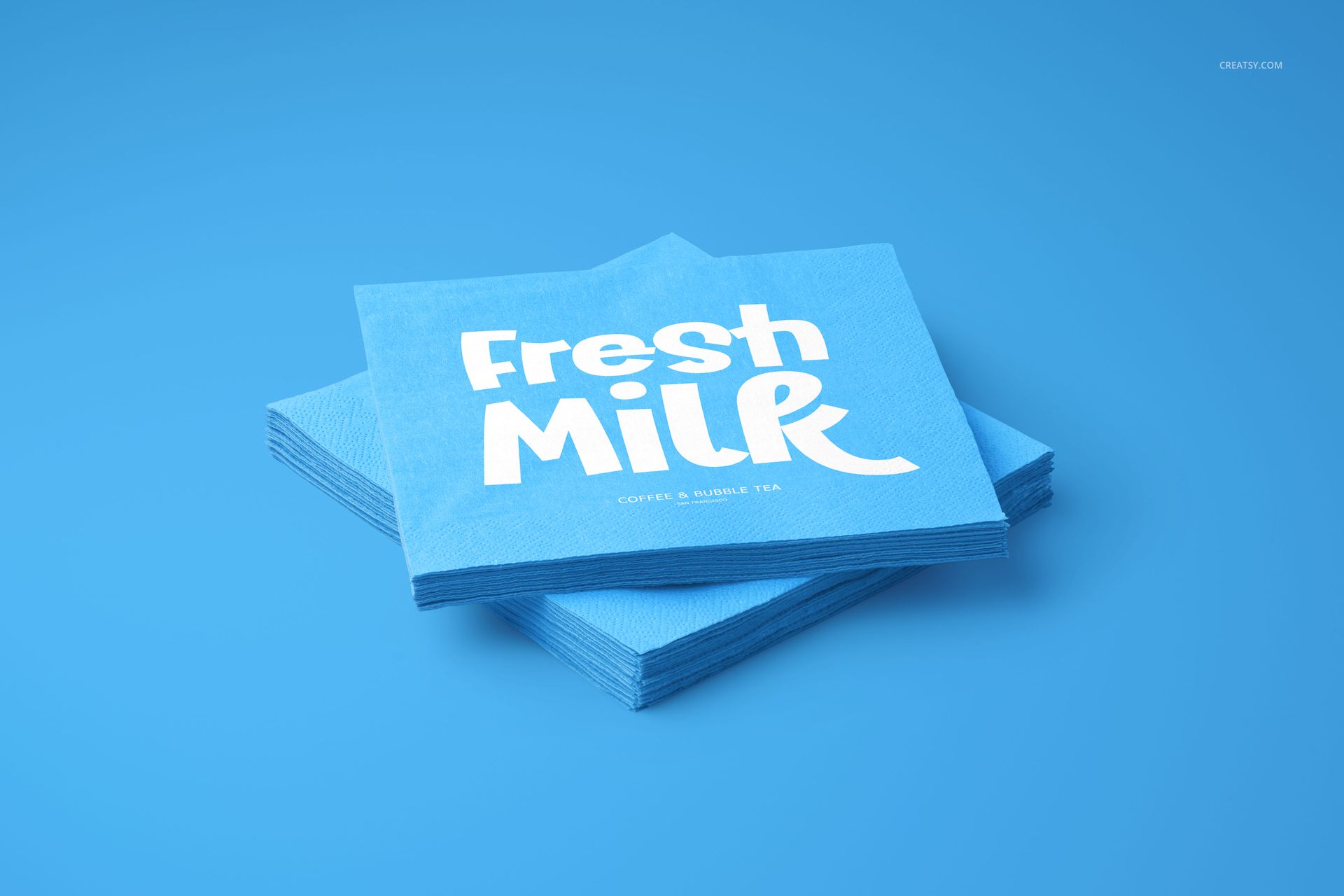 Blue napkin mockup set featuring square napkins with white lettering, viewed from a slightly elevated angle.