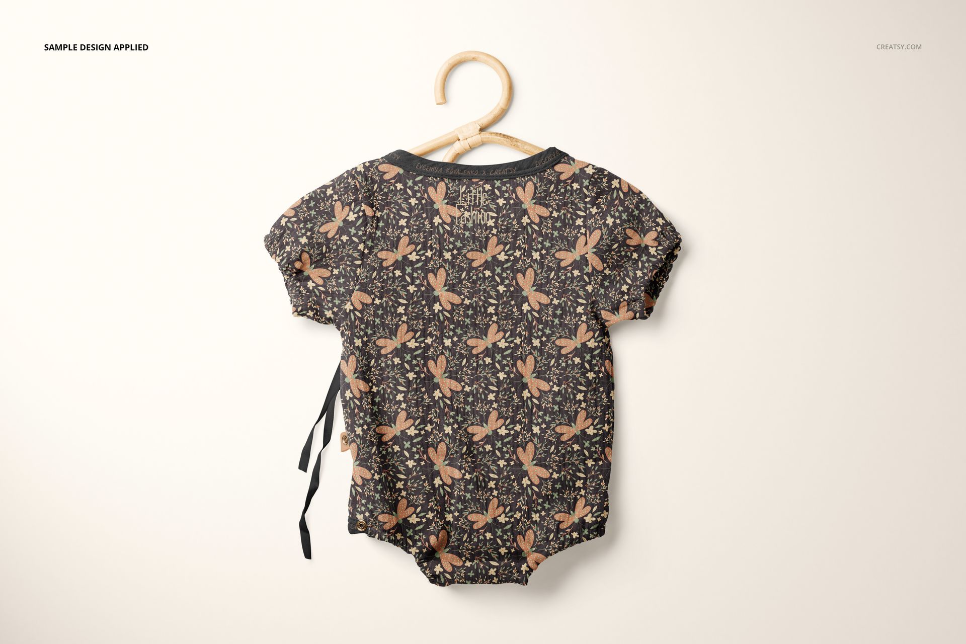Muslin onesie mockup featuring a dark floral print, shown from the back on a hanger against a light background.