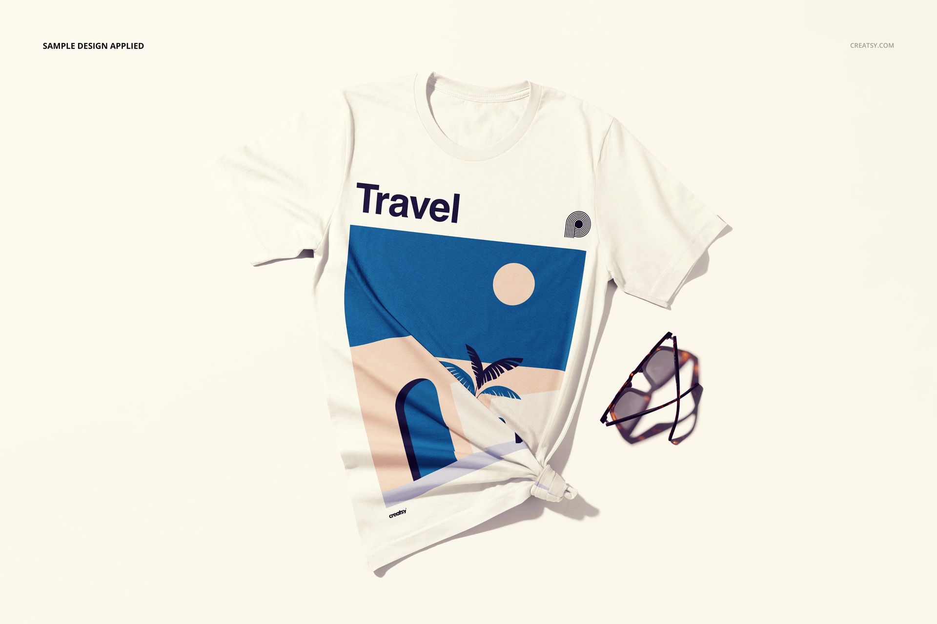 Front view of a white t-shirt mockup with a minimalist travel design, styled with a knot and sunglasses beside it.