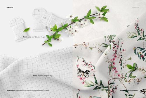 PSD mockup showing draped fabric with a botanical design, thread cards, and a branch with white flowers on a neutral background.