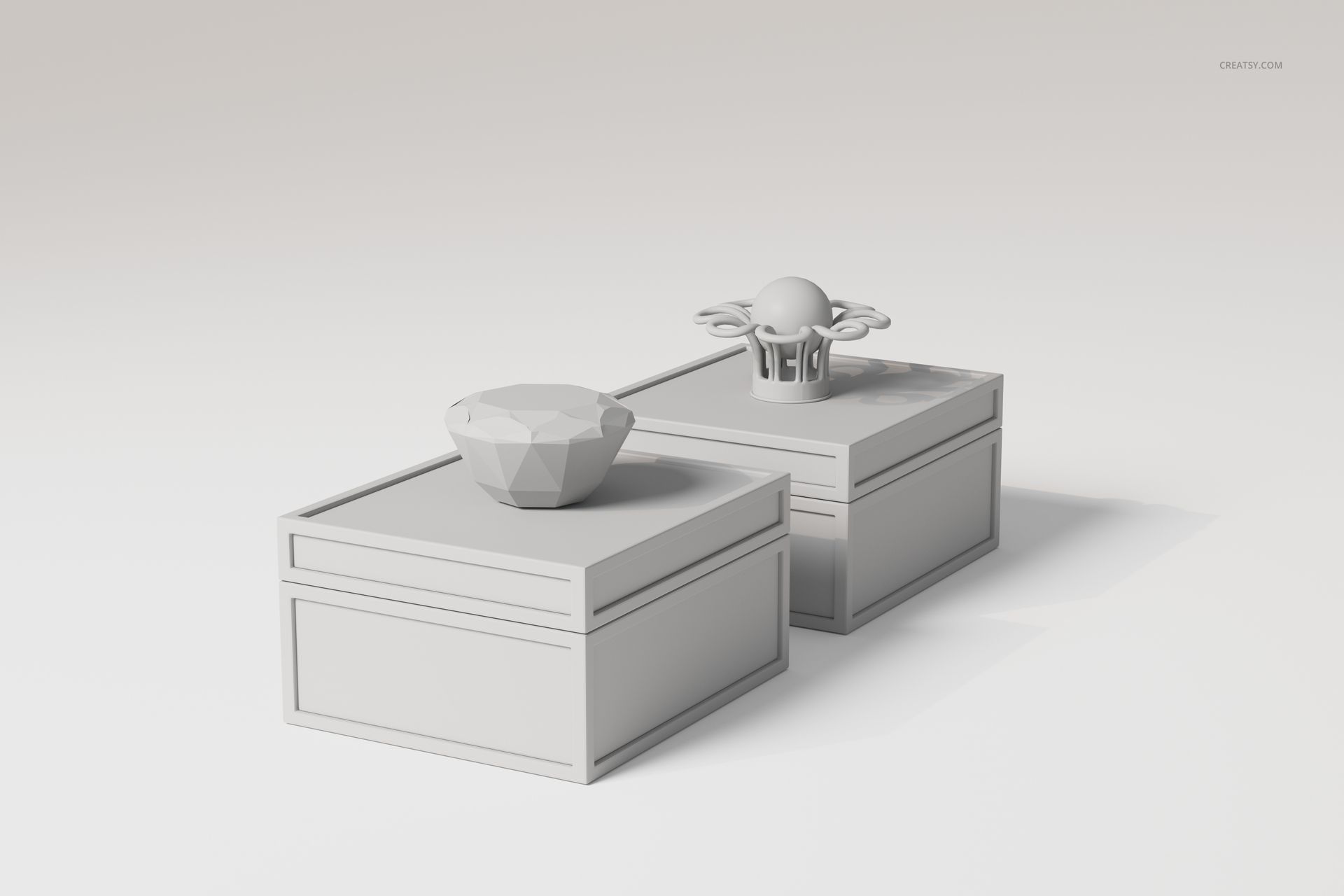 Two art deco jewelry boxes in light gray, shown from a front angle on a plain background, with geometric lids.