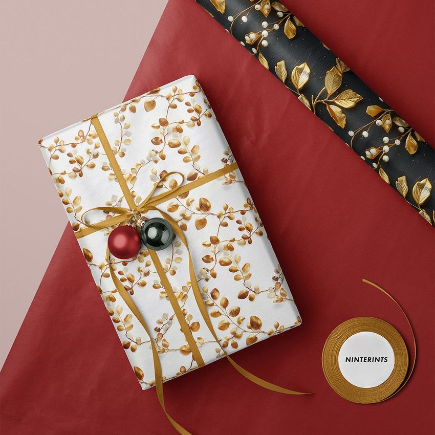 Gift and wrapping paper mockup featuring a present wrapped in white paper with golden berry pattern, gold ribbon, and ornaments.