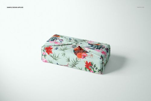 Furoshiki fabric wrap mockup featuring a pastel base with vibrant flowers and roosters, shown in a studio setting.
