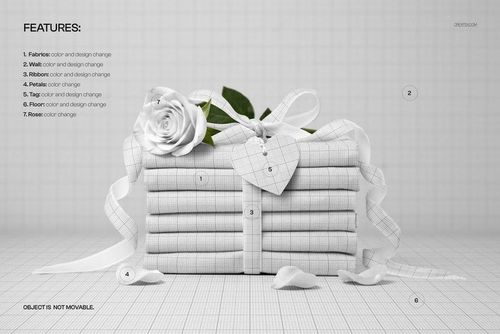 Stack of folded fabric with a grid pattern, decorated with a white rose and velvet ribbon, front view mockup.