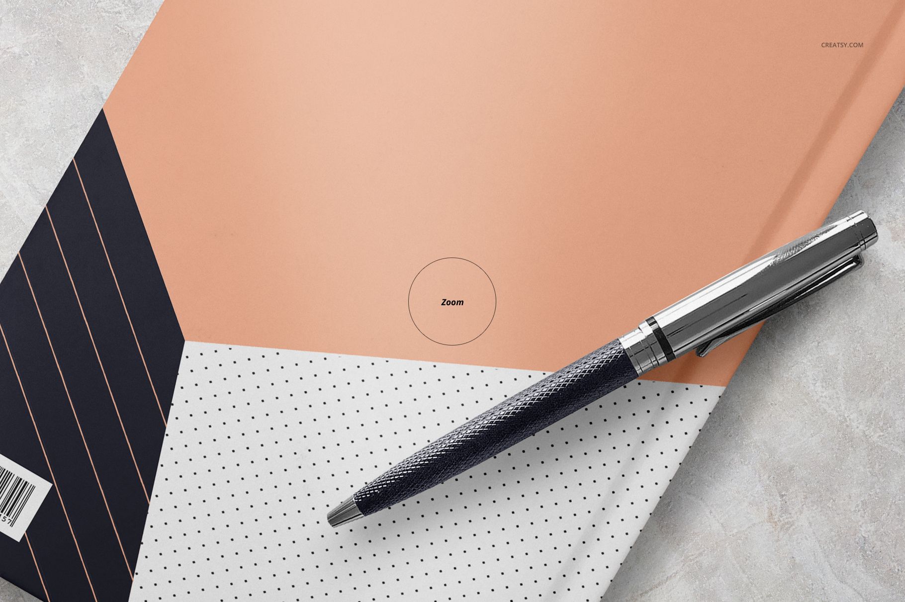 Notebook mockup featuring a modern cover with diagonal peach, black, and dotted white sections, shown with a metallic pen.