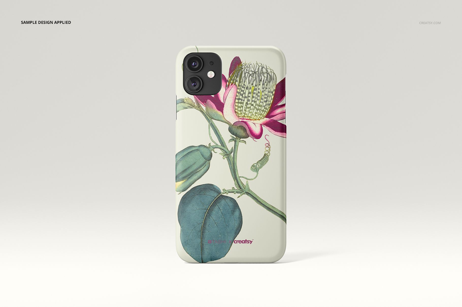 Single iPhone 11 matte case mockup with botanical artwork, including a pink flower and green foliage, displayed on a neutral surface.