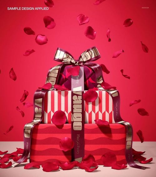 PSD mockup featuring a pile of gift boxes wrapped in red and gold, adorned with rose petals and ribbon bows.