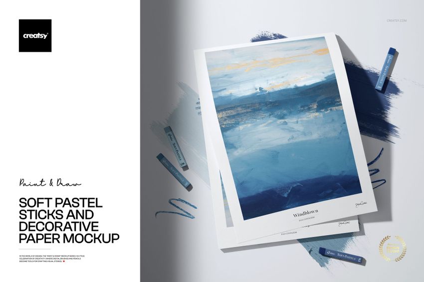 PSD mockup featuring soft pastel sticks placed near decorative paper with abstract blue and gold painting, top view.