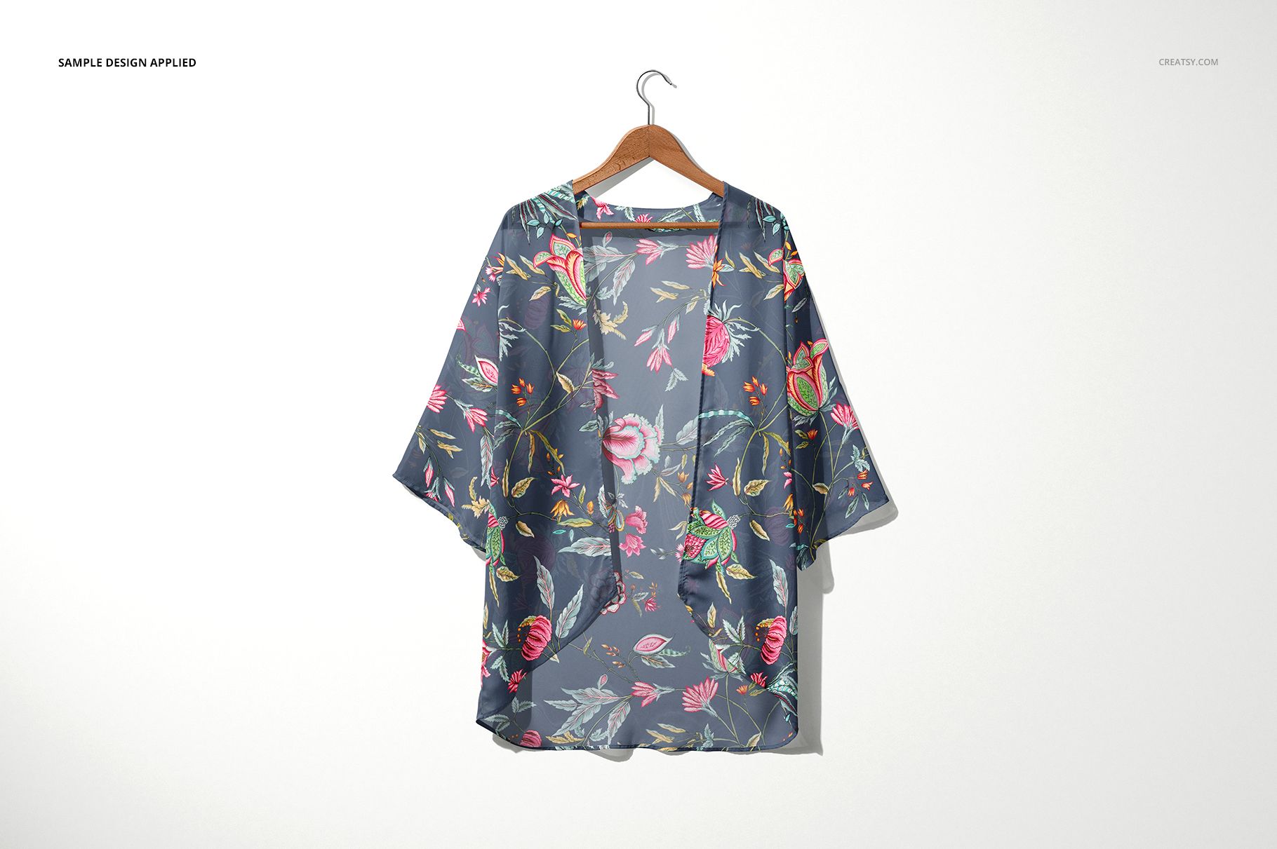 Front view of a chiffon kimono mockup with a colorful floral pattern, displayed on a wooden hanger against a light wall.