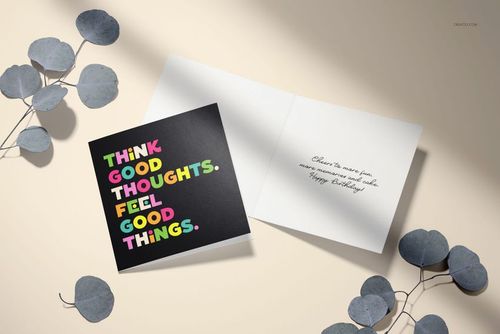 Square folded greeting cards mockup showing one card with colorful text and another opened to reveal handwritten message.