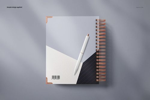 Top view of a wire-bound planner mockup with a pen on the cover, featuring abstract patterns and copper spiral binding.