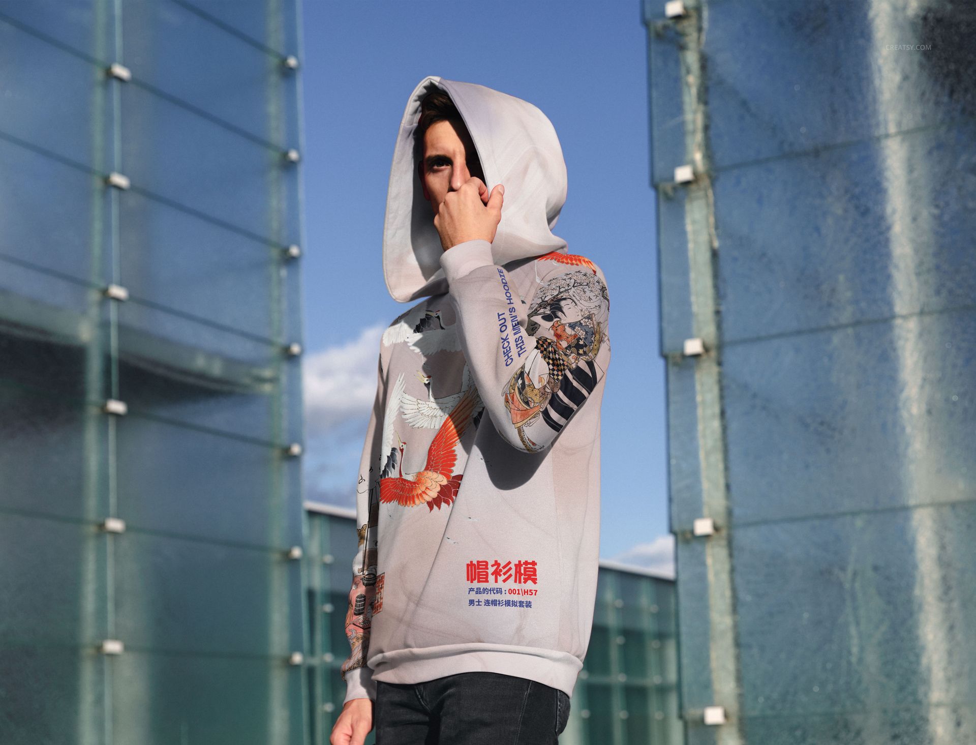 Oversized hoodie with large hood featuring colorful graphic designs, shown outdoors in front view mockup.