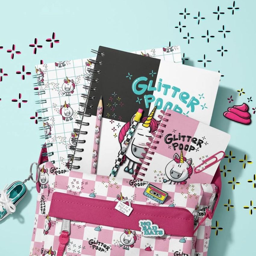 School backpack mockup with spiral notebooks, pencils, and erasers featuring unicorn and glitter designs on a pastel background.
