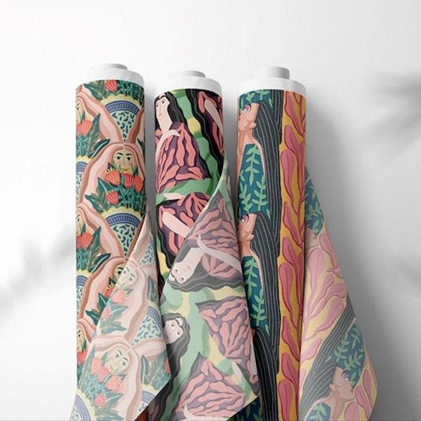 Three fabric rolls mockup featuring colorful, artistic patterns with abstract human figures and botanical elements on a white background.