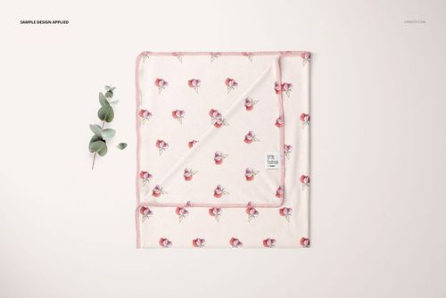 Swaddle blanket mockup featuring a soft pink fabric with a floral pattern, shown from a top view with a folded corner.