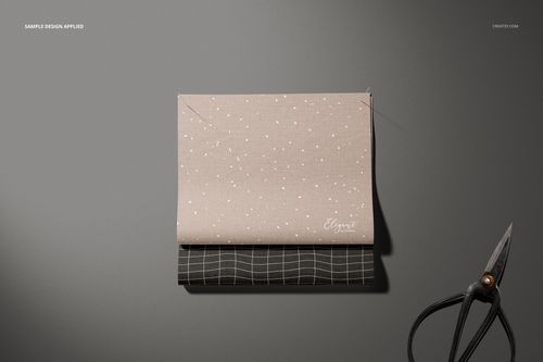 Fabric swatches mockup showing a beige dotted fabric layered over a black grid fabric, scissors placed beside them.